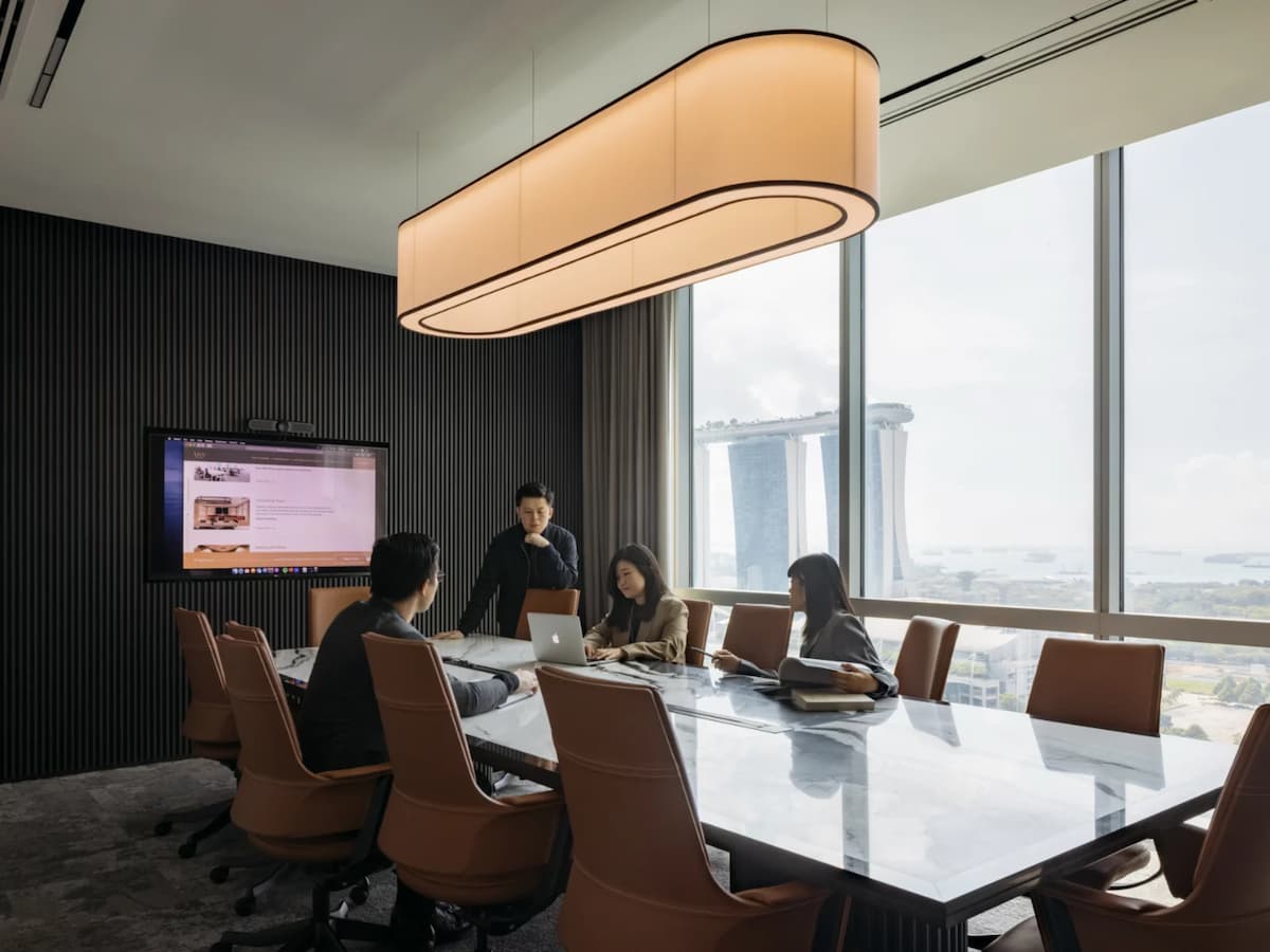 a group of professionals is engaged in a discussion in a modern boardroom