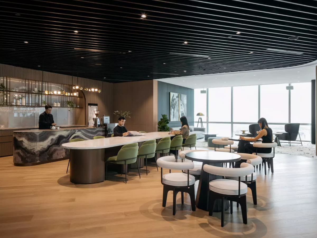 people sitting in a lounge space with a large, stylish marble counter and bar seating