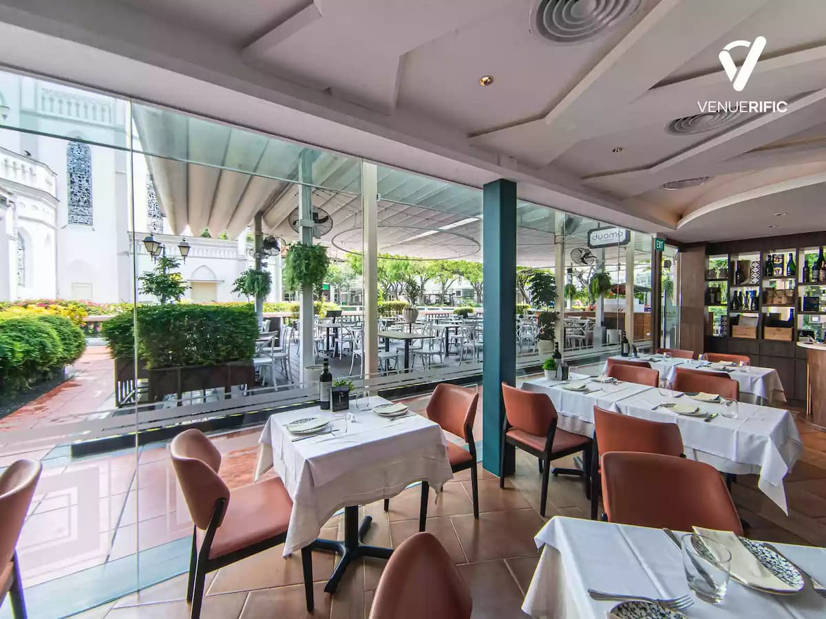indoor view with glass walls showcasing outdoor seating and greenery