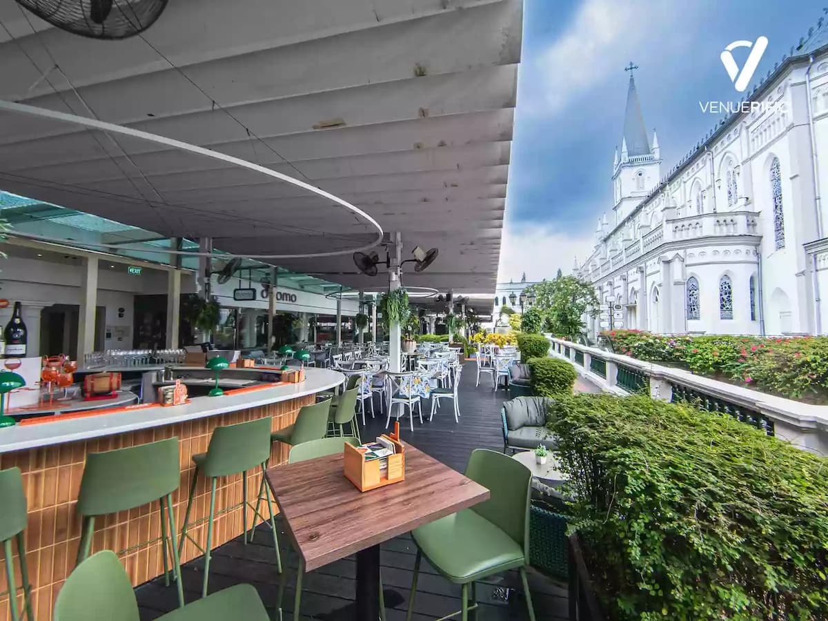 stylish outdoor bar and terrace with greenery and church backdrop