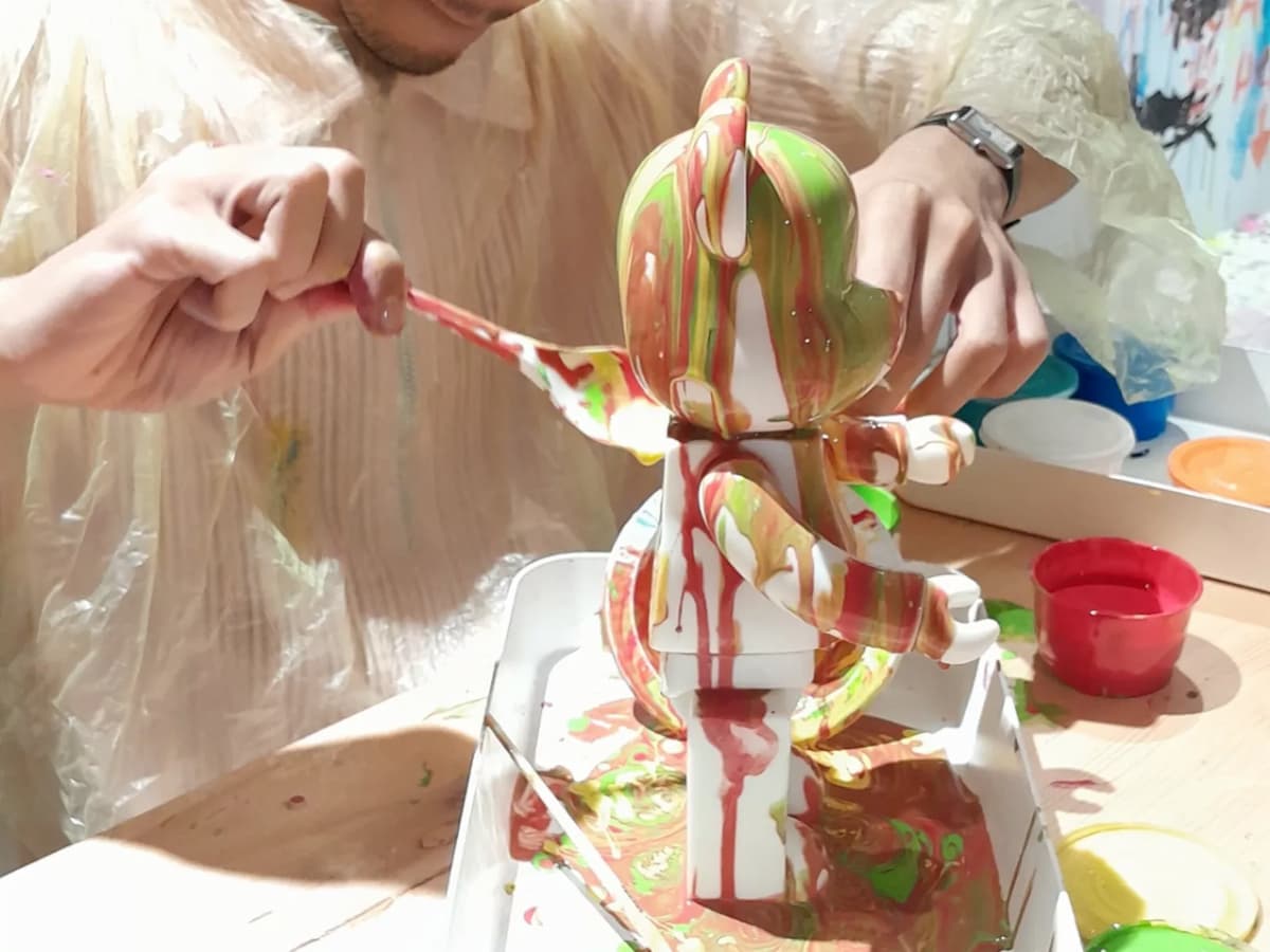 painting a small figurine with colorful paints