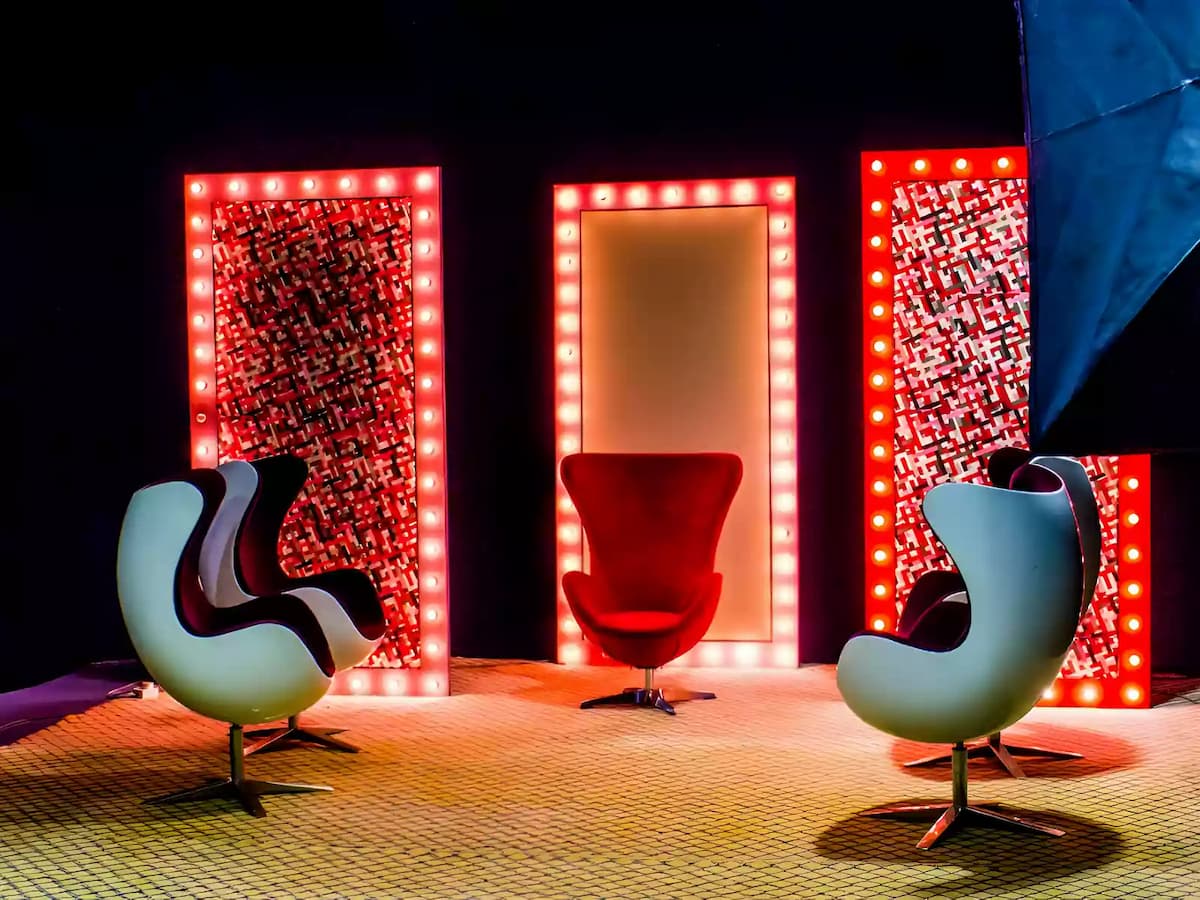 a creative setup with four chairs in a modern, retro style, illuminated by bright, red light bulbs