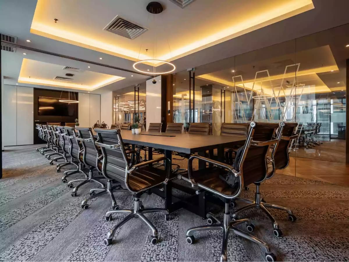 a luxurious and modern meeting room with a large wooden conference table and sleek leather chairs on casters