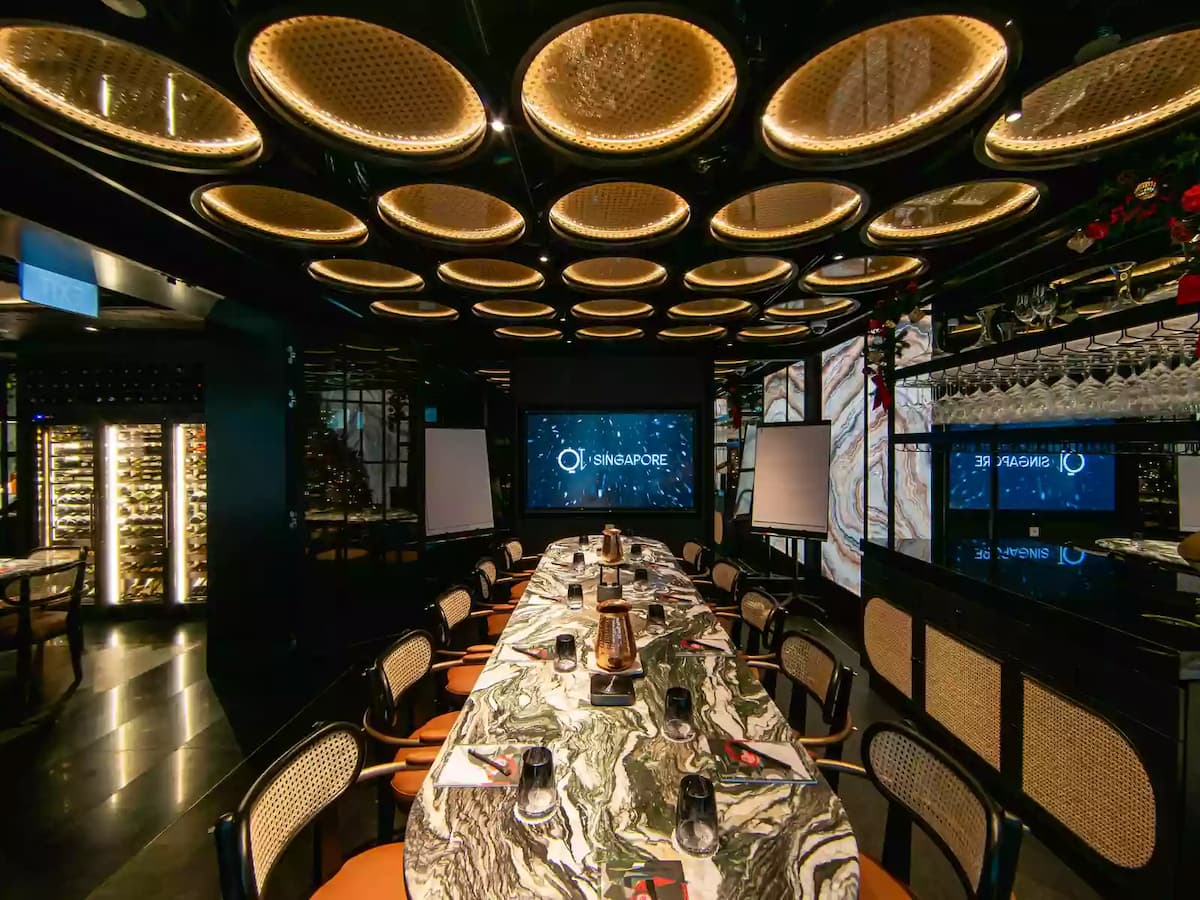 an elegant space with a marble table, stylish chairs, a presentation screen, and modern circular ceiling lights