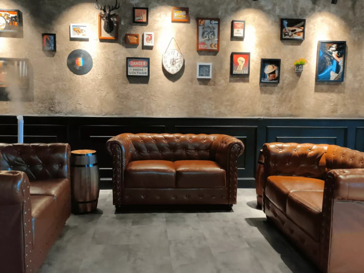 A cozy lounge with vintage-inspired décor featuring rich brown leather sofas