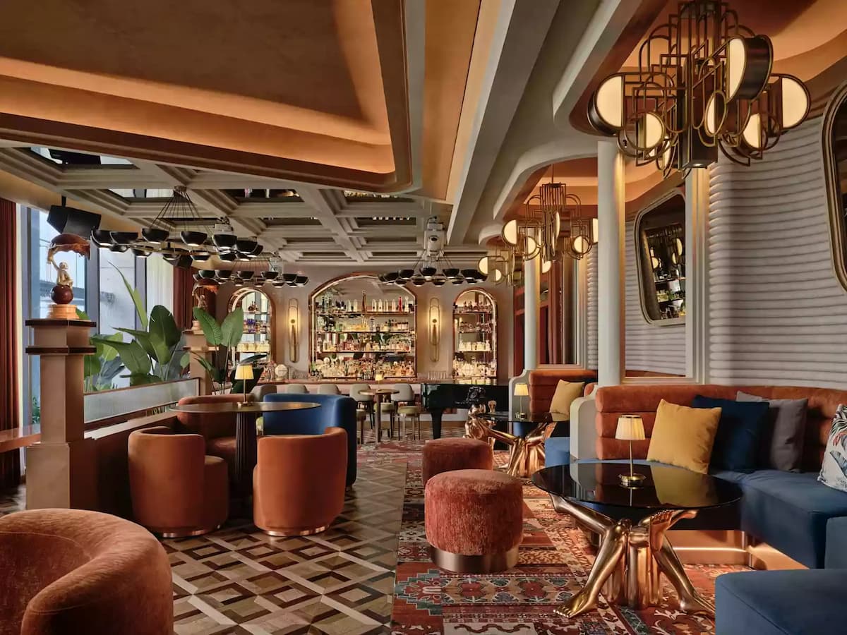 a lavish and elegantly designed lounge with plush velvet seating in warm earthy tone