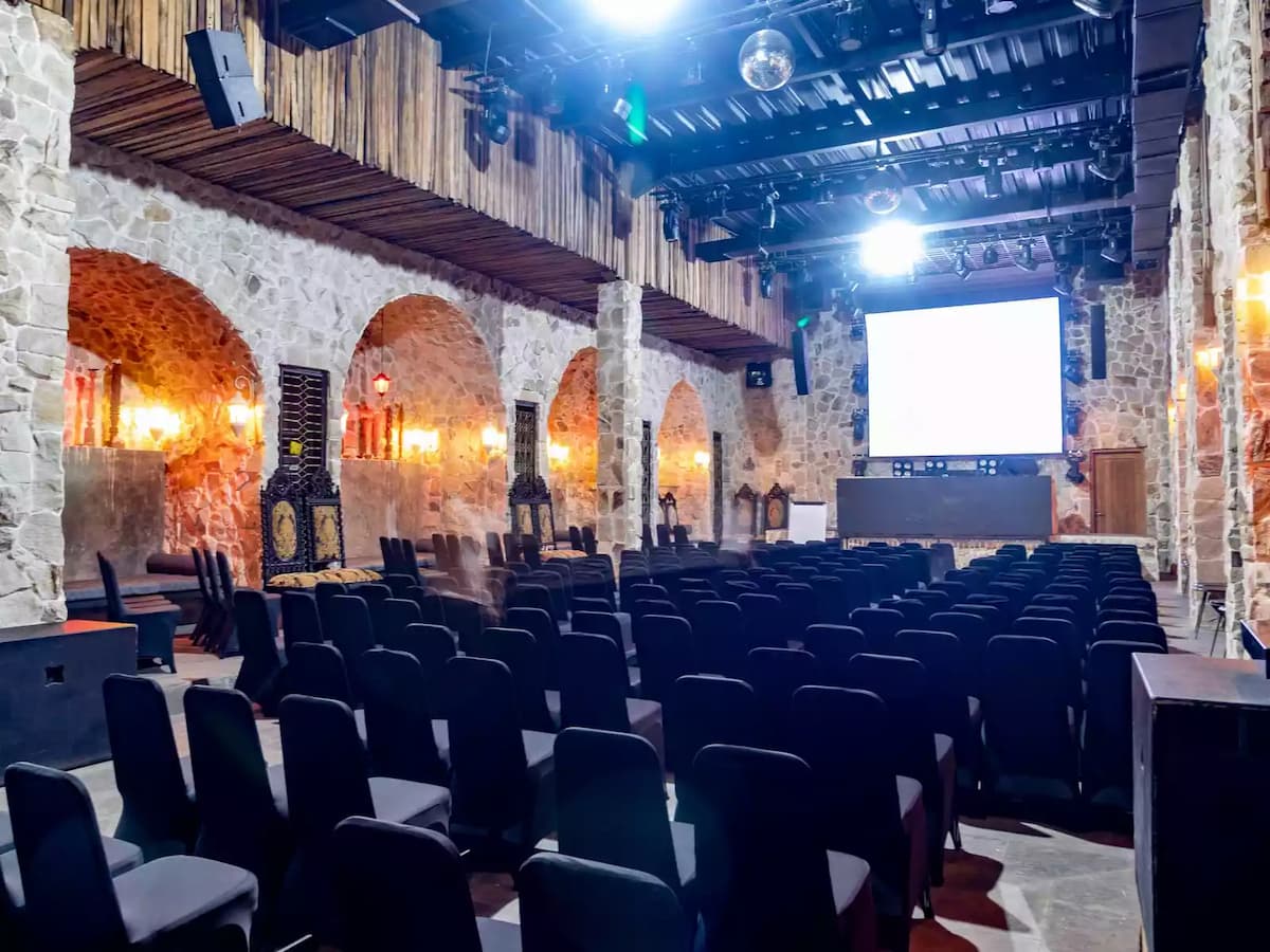 rows of black chairs facing a big screen