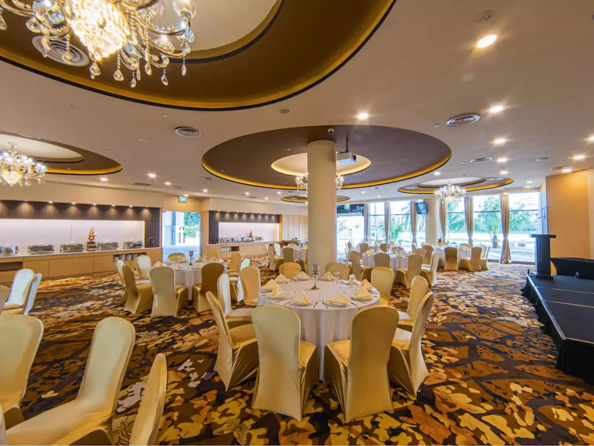 round tables with gold-upholstered chairs, sparkling chandeliers, a stylish buffet area