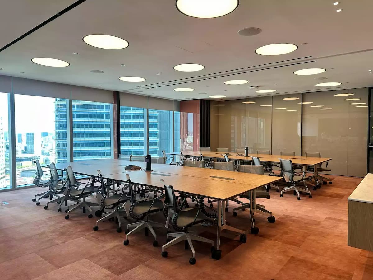 Flexible training and meeting room with modular tables, ergonomic chairs, and city views.