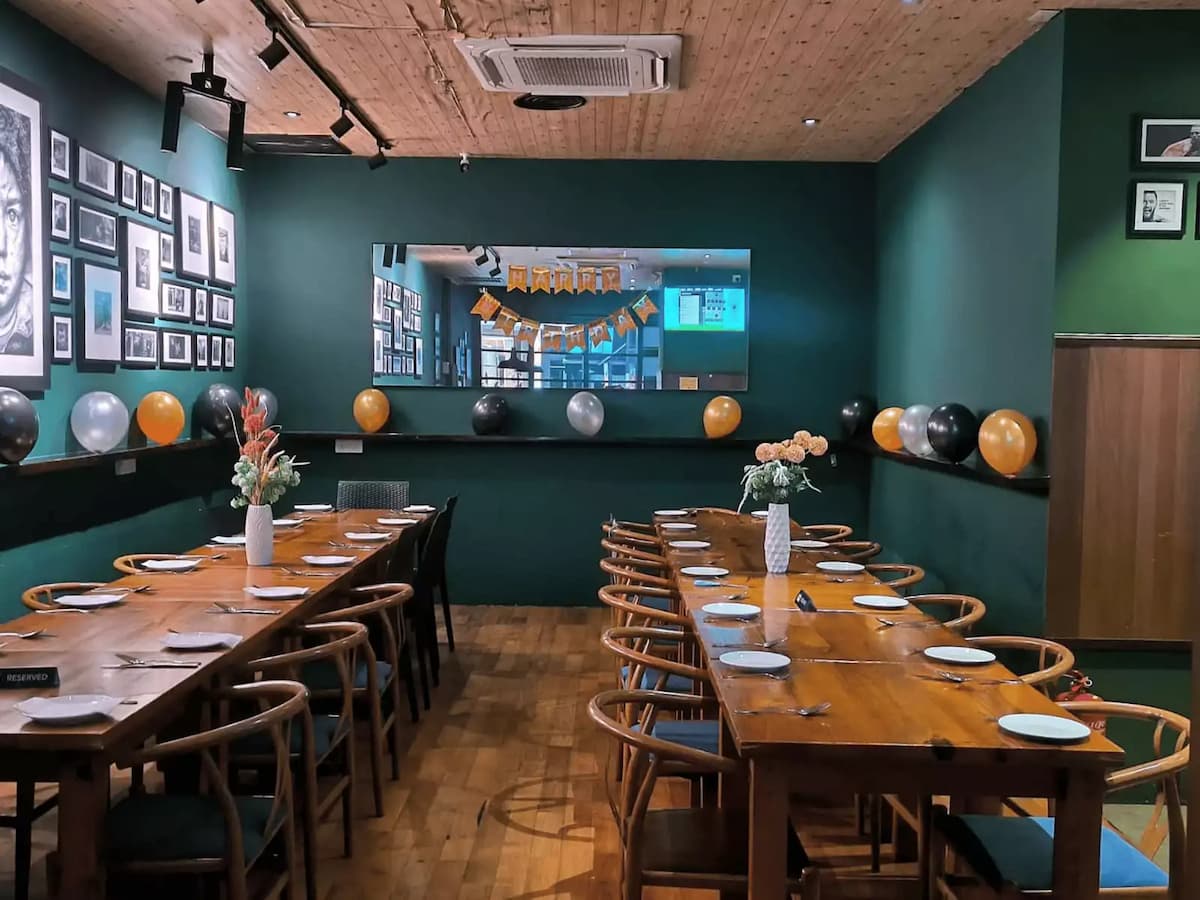 A private dining area decorated with balloons, flowers, and a birthday banner setup