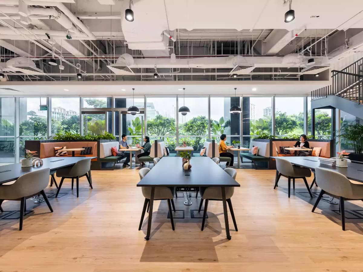 Modern coworking space with communal tables and cozy lounge seating.