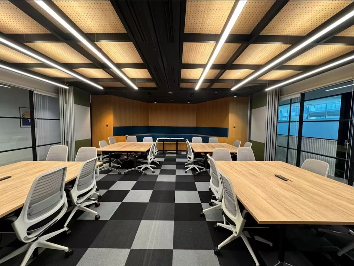 Modern collaborative workspace with meeting tables and ergonomic office seating.