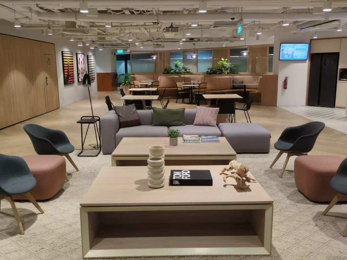 Modern coworking lounge with comfortable seating and communal workspace area.