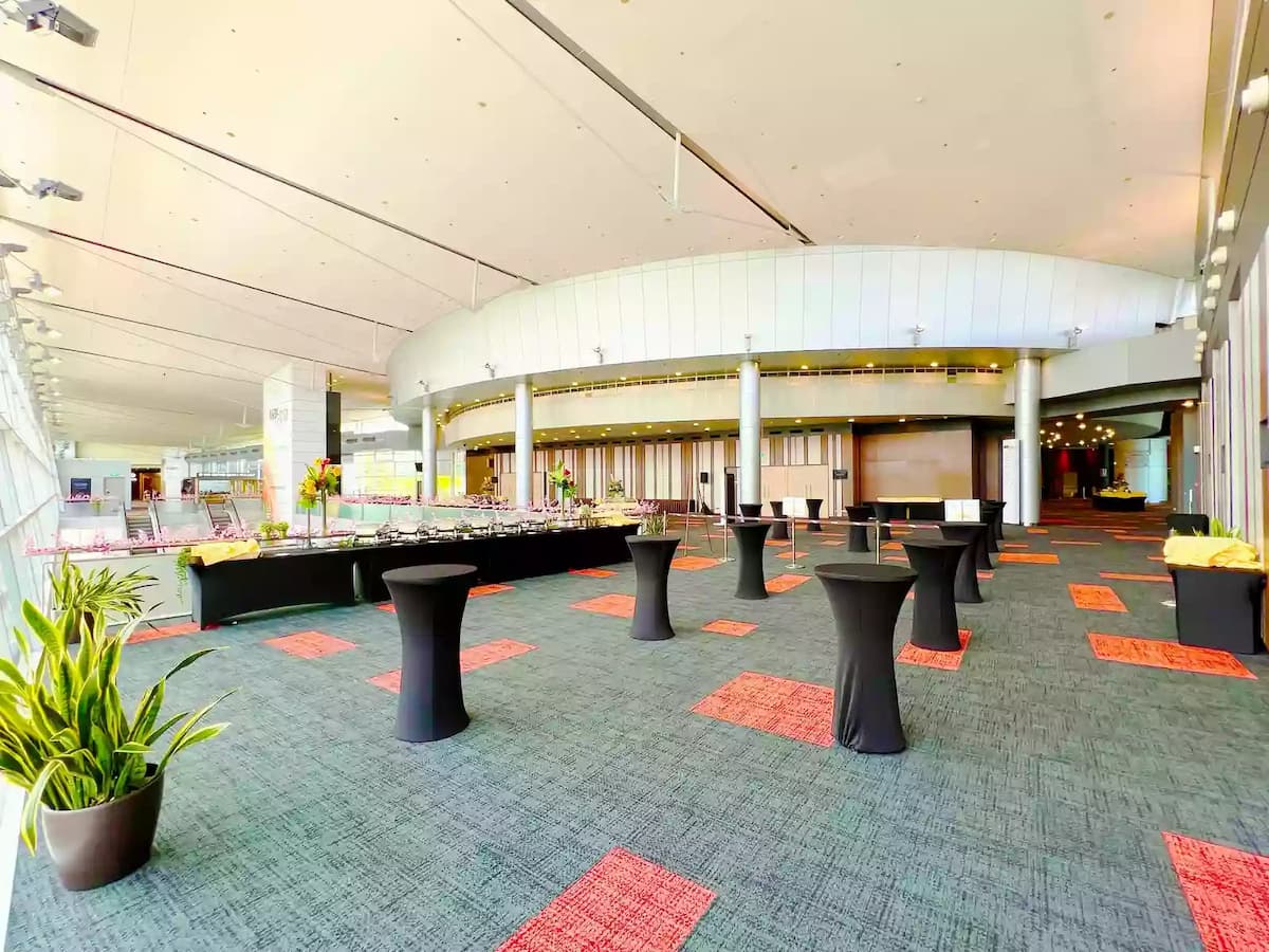 Spacious event foyer setup with cocktail tables and buffet stations.