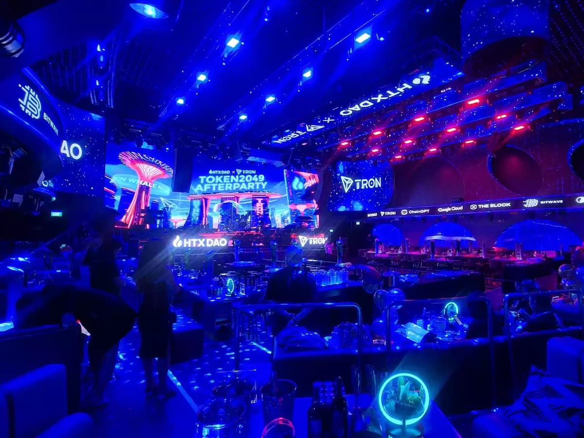 Large immersive nightlife venue with massive LED screens, dynamic stage lighting, and lounge-style seating