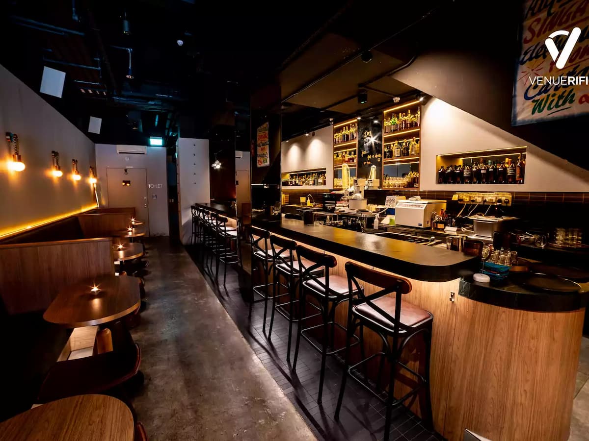 Cozy modern bar interior with counter seating and warm lighting.