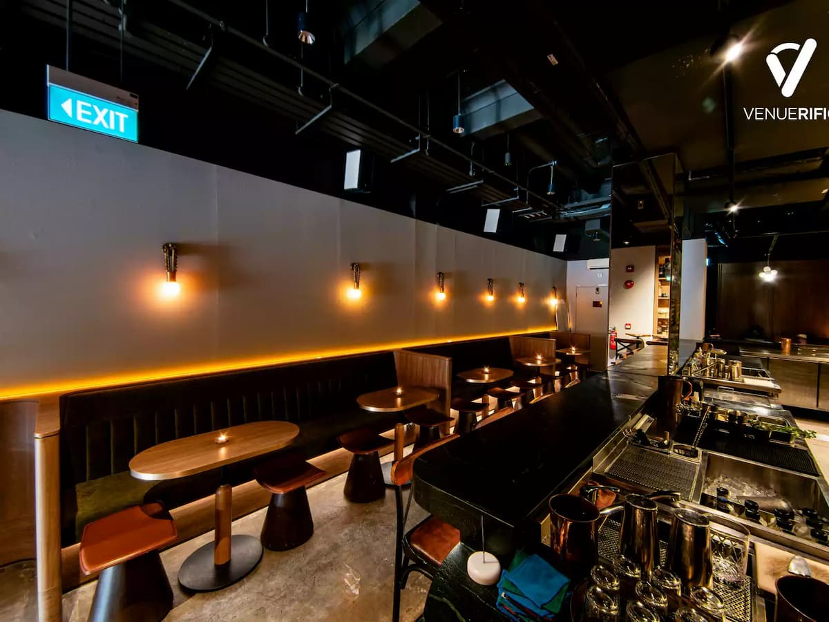 Stylish cocktail bar with intimate booth seating and warm lighting.