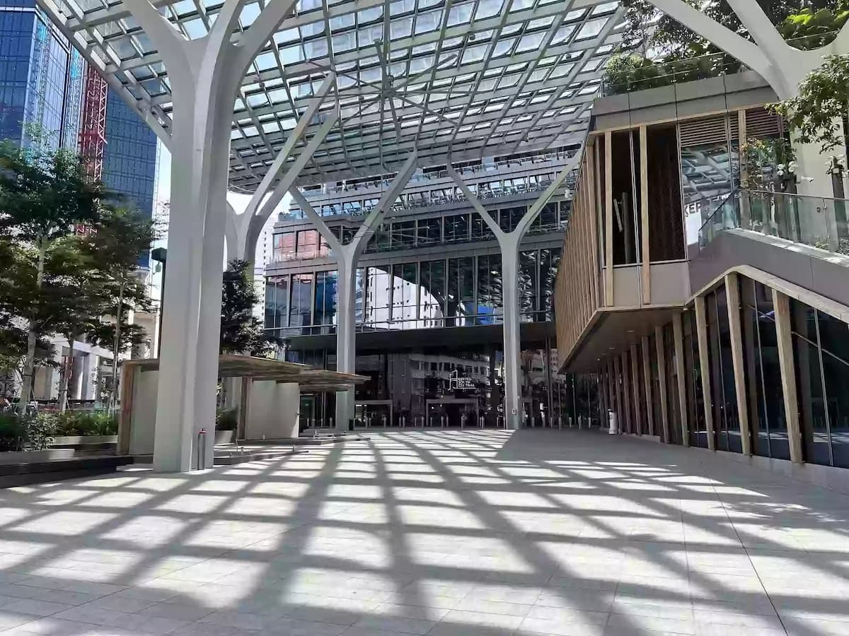 Open-air urban plaza with modern architecture and glass canopy.