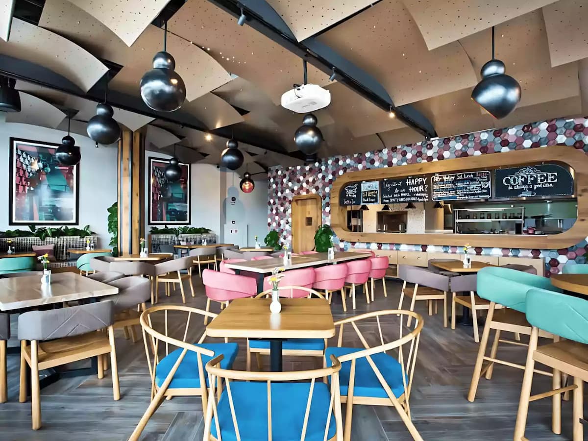 Modern café interior with colorful seating and stylish decor.