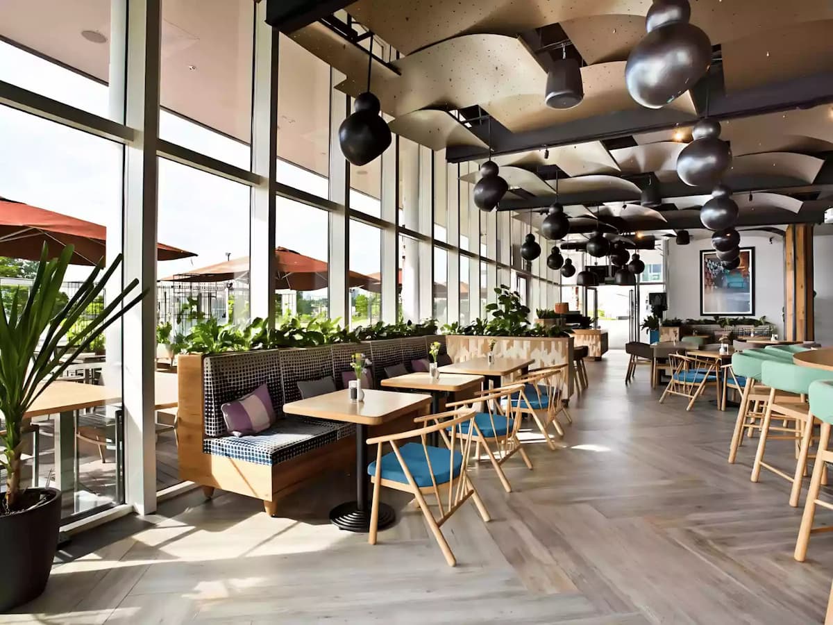 Bright café interior with floor-to-ceiling windows and cozy seating.