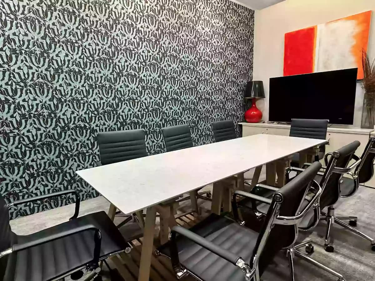 Modern meeting room with conference table and black office chairs.