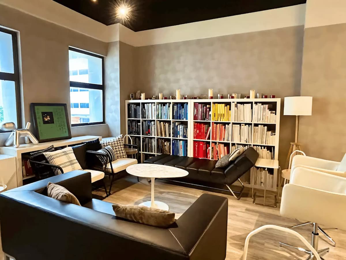 Cozy lounge area with modern seating and colorful bookshelf display.