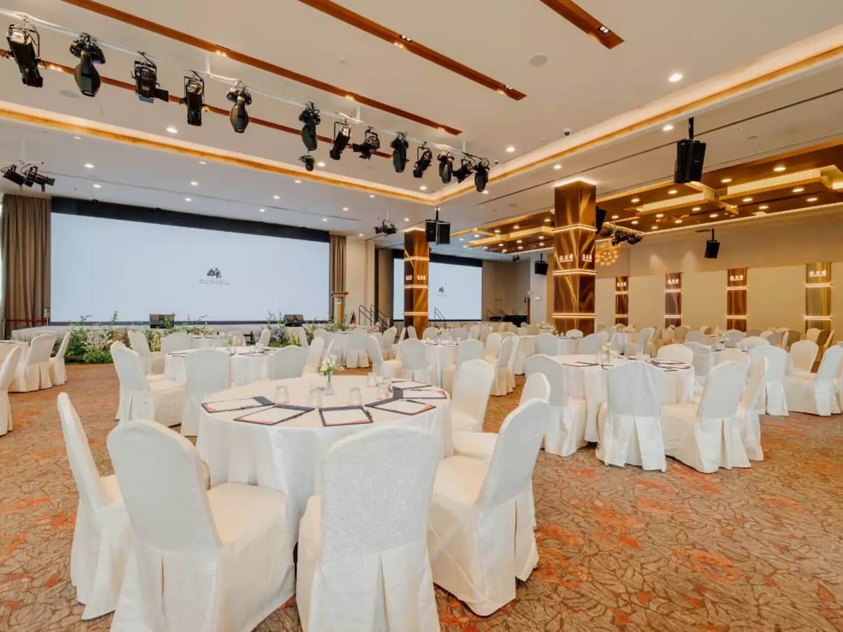 Elegant ballroom venue with round banquet seating and professional stage setup.