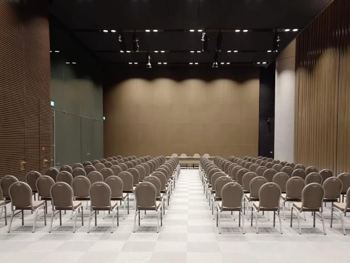 Theatre-style conference room with rows of chairs and stage area.