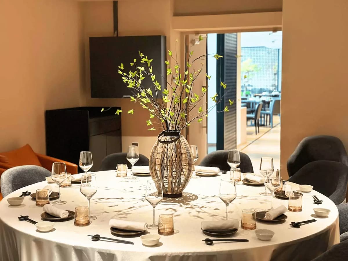 Private dining room with round table, elegant table setting, and floral centerpiece.