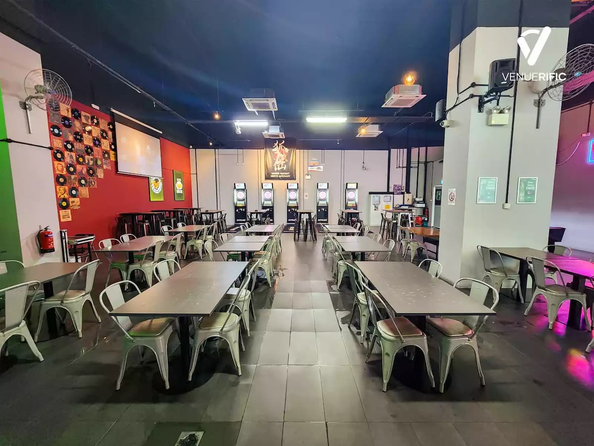 Spacious darts venue with long tables, electronic boards, and casual seating.
