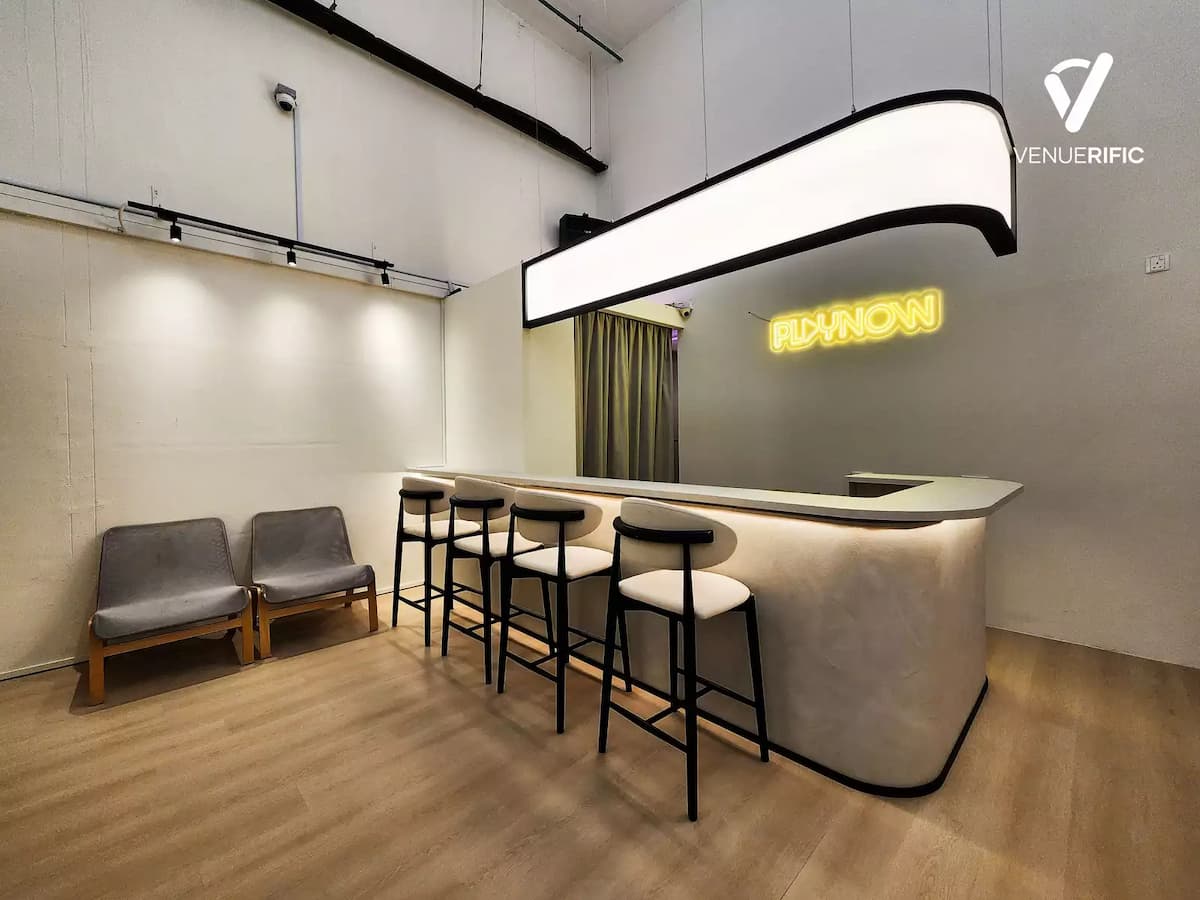 Minimalist event studio bar with modern stools and soft lighting.