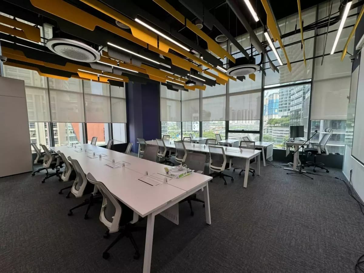 corporate training room with long white tables and floor to ceiling city views at an event venue in kuala lumpur