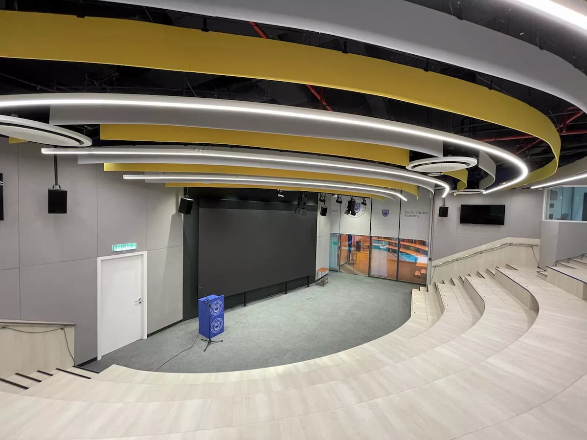 auditorium stage with curved lighting ceiling and speaker system inside an event space near mid valley