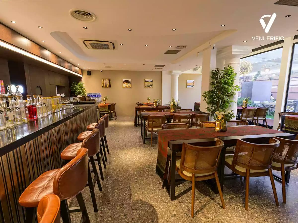 Bright café-style event space with bar seating, wooden tables, and natural light.