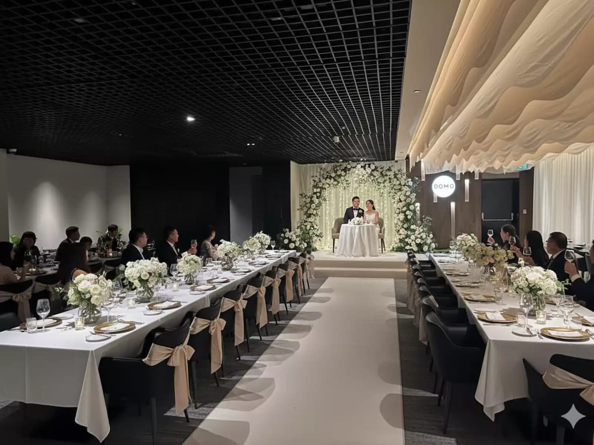 Elegant wedding banquet with long tables, floral decor, and couple at head table.