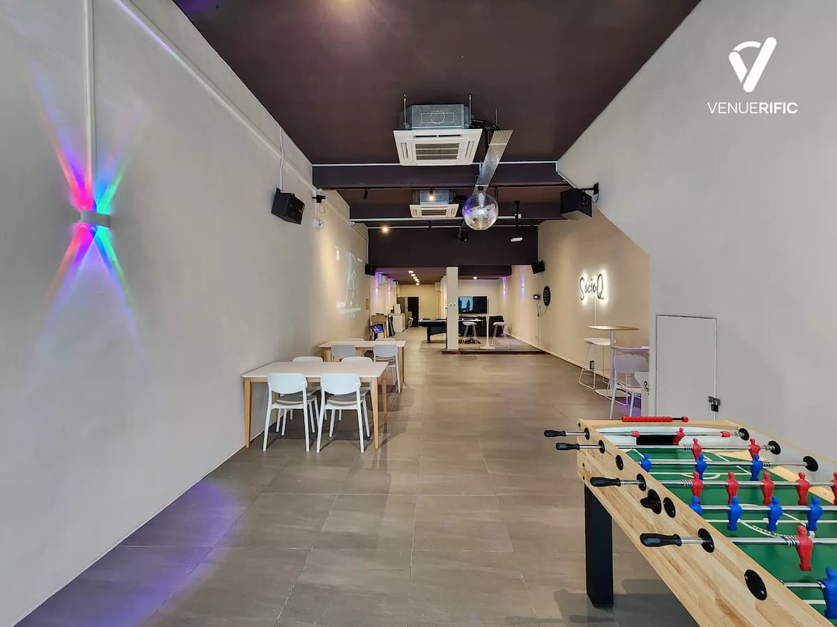 SocioQ event space with casual seating, foosball table, high ceilings, disco ball, and minimalist white interior designed for social and interactive events.