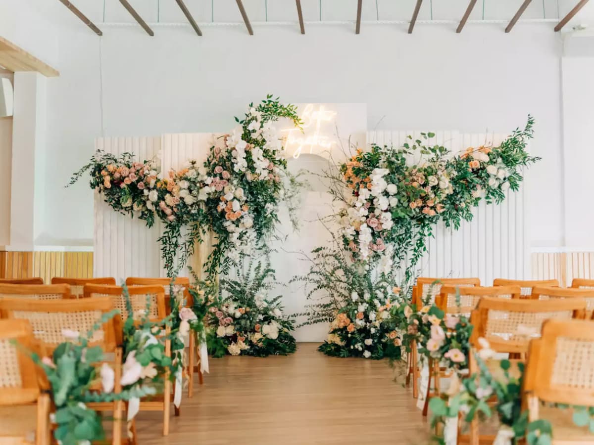 Romantic wedding ceremony setup with floral arch and elegant aisle seating.