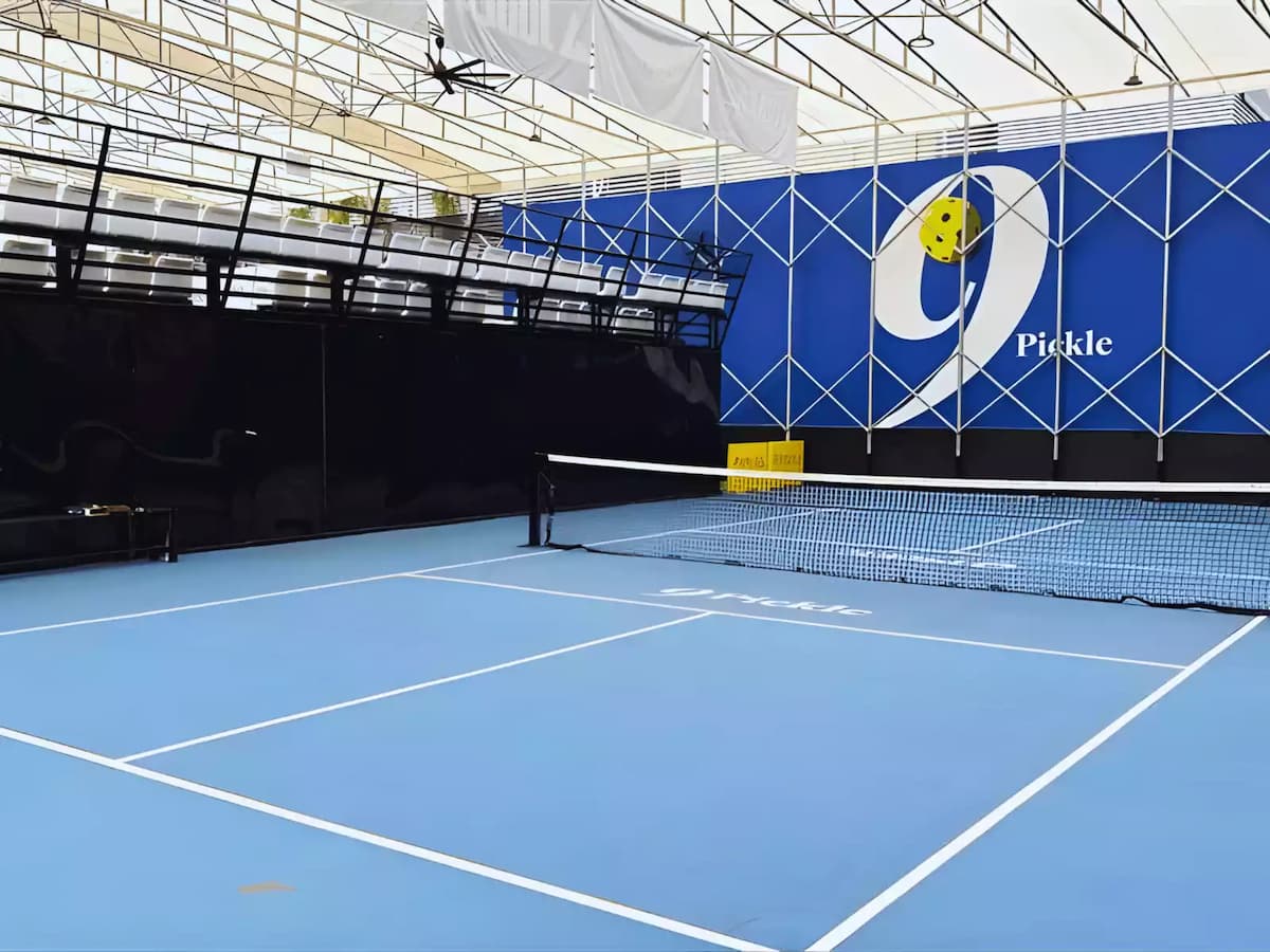 Covered pickleball court with blue playing surface and net setup