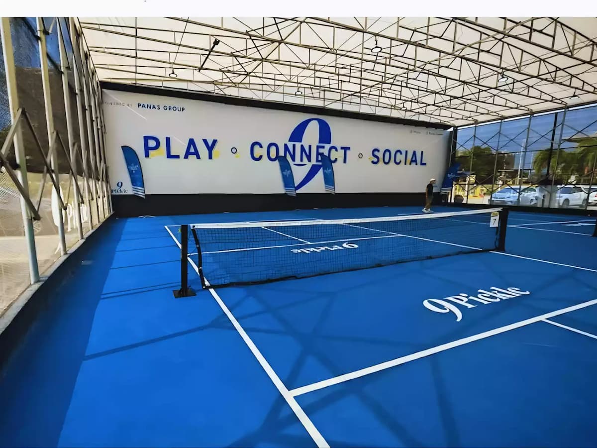 Covered pickleball court with blue playing surface and net setup