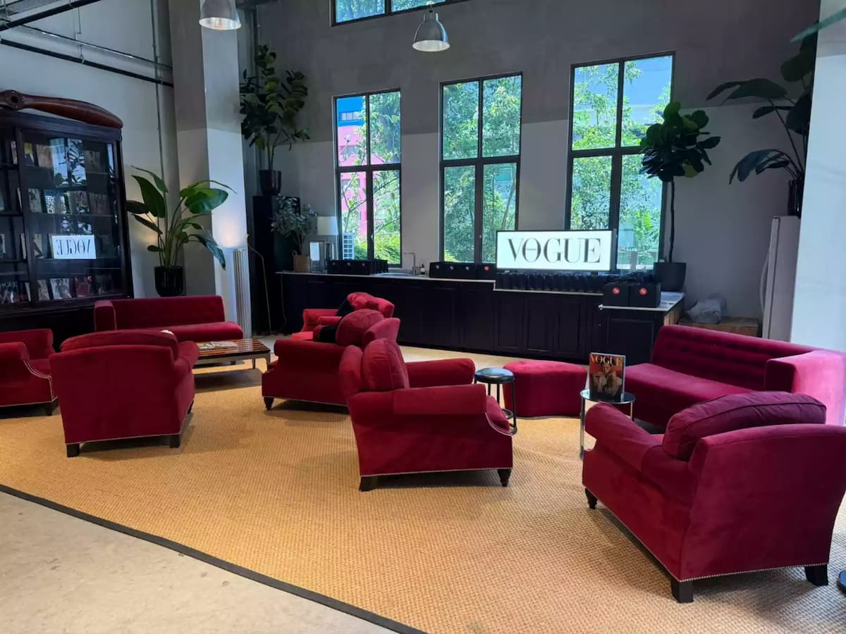 Stylish lounge area with red velvet sofas and large windows.