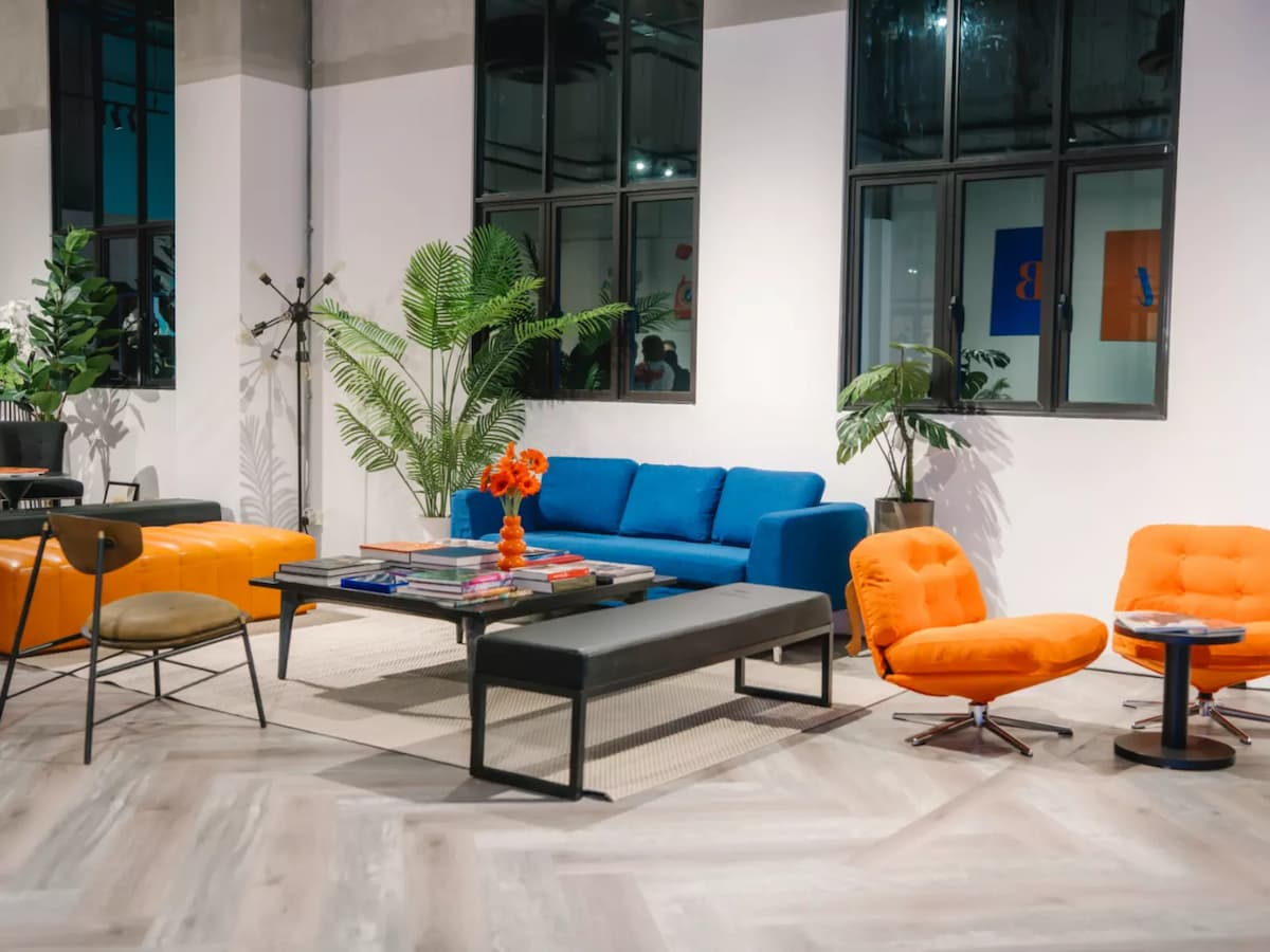 Modern lounge seating with colorful sofas and indoor plants.