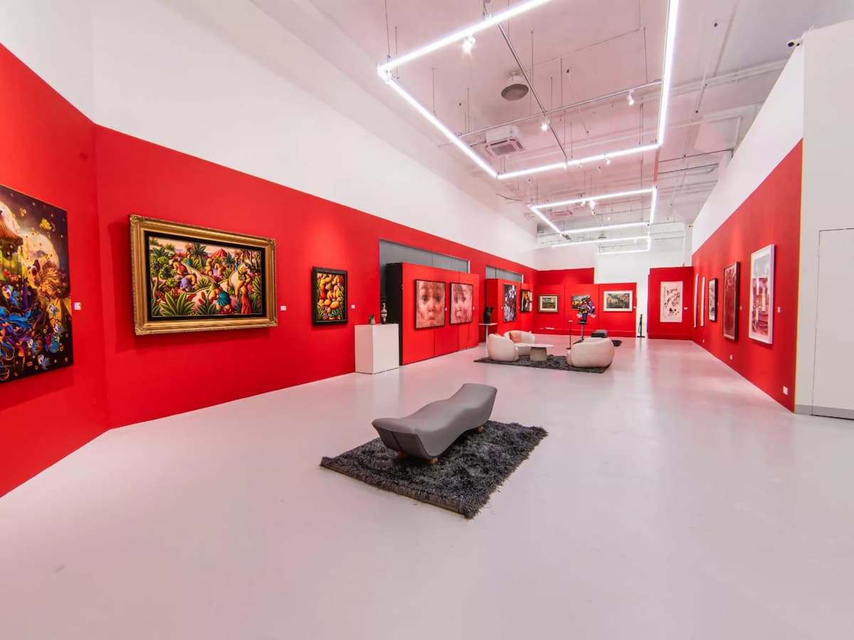 Contemporary art gallery with red walls and curated artworks.