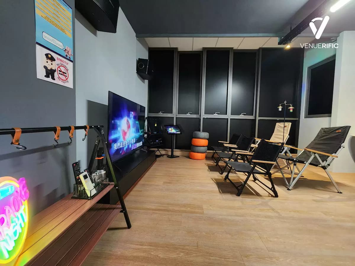 Relaxed screening or gaming room with TV setup, lounge chairs, neon accents, and a cozy entertainment vibe.