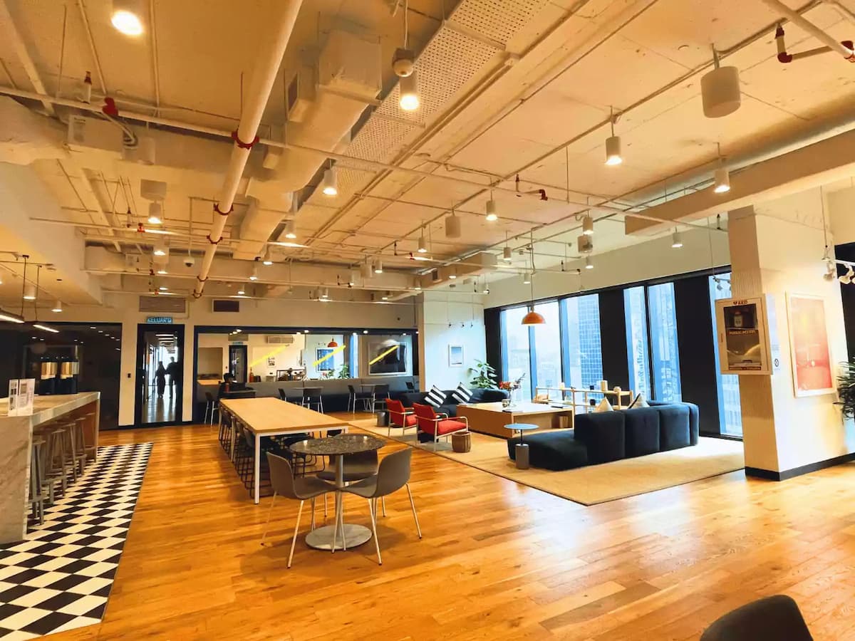 flexible event space with communal tables lounge seating and large windows at wework equatorial plaza kuala lumpur