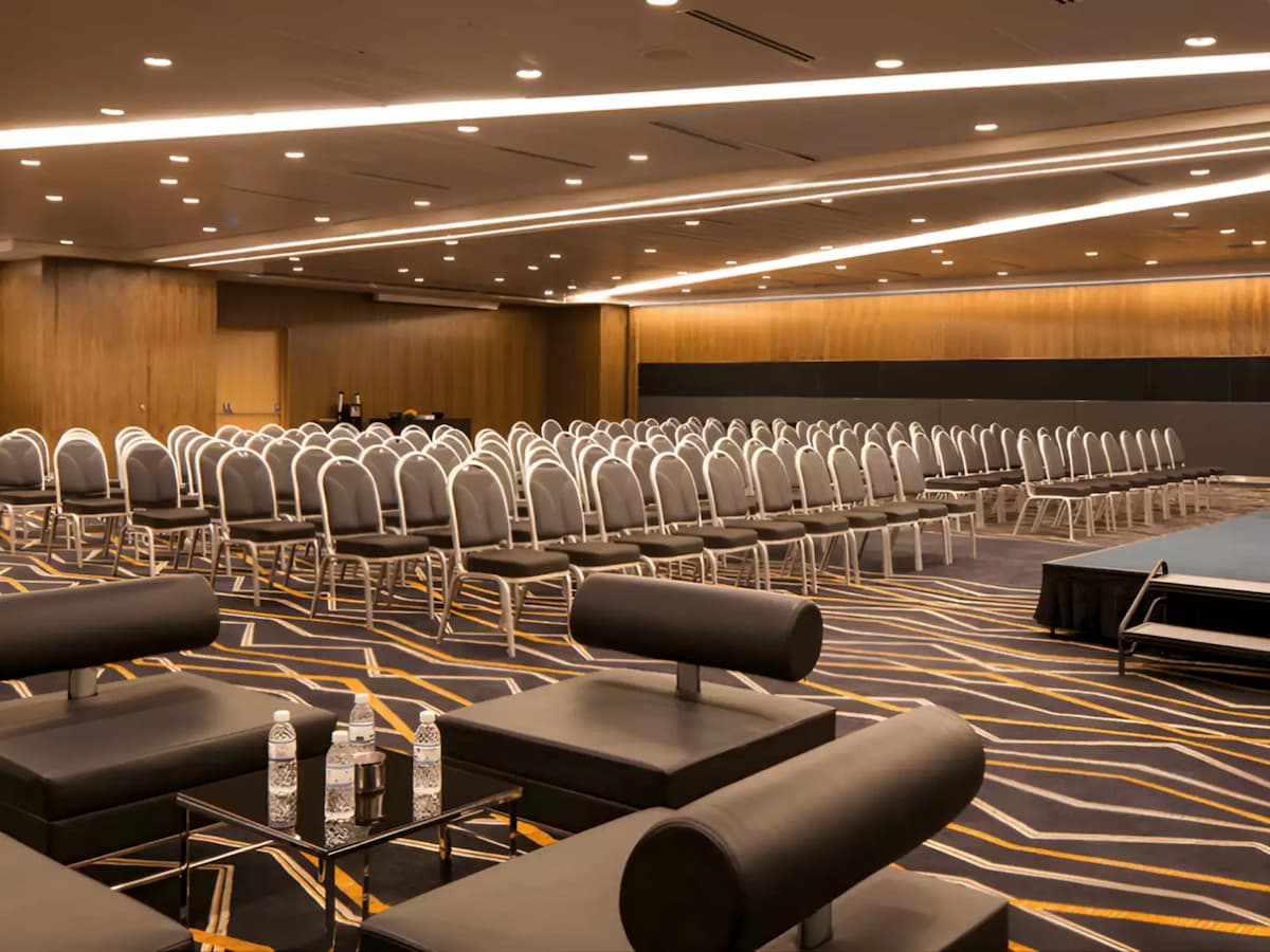Large conference hall with theatre seating, stage, and modern lighting.