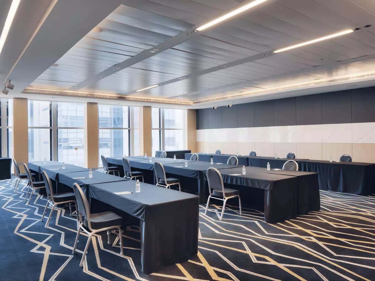Contemporary meeting room with classroom tables, city views, and modern lighting.