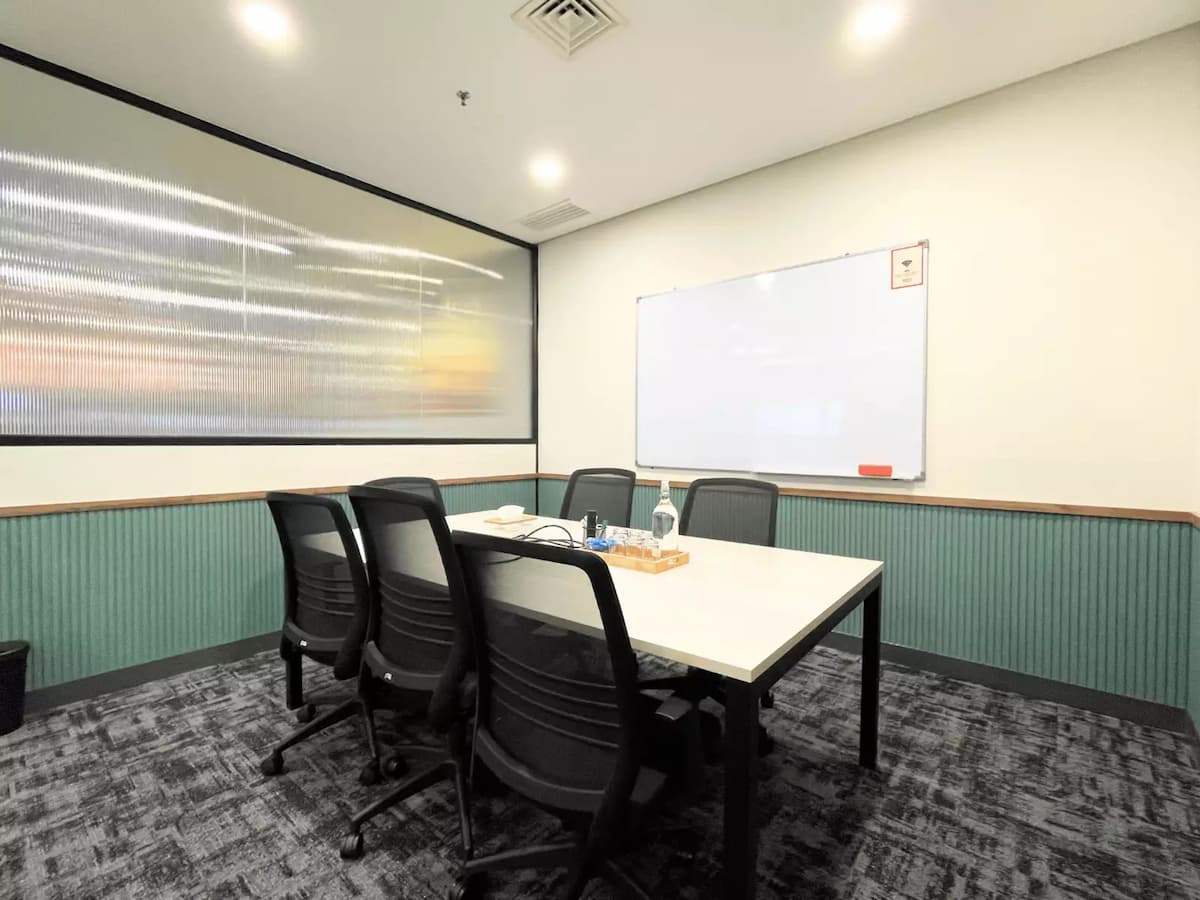 compact discussion room with green fluted wall panels whiteboard and carpeted floor at an affordable meeting space in kl sentral