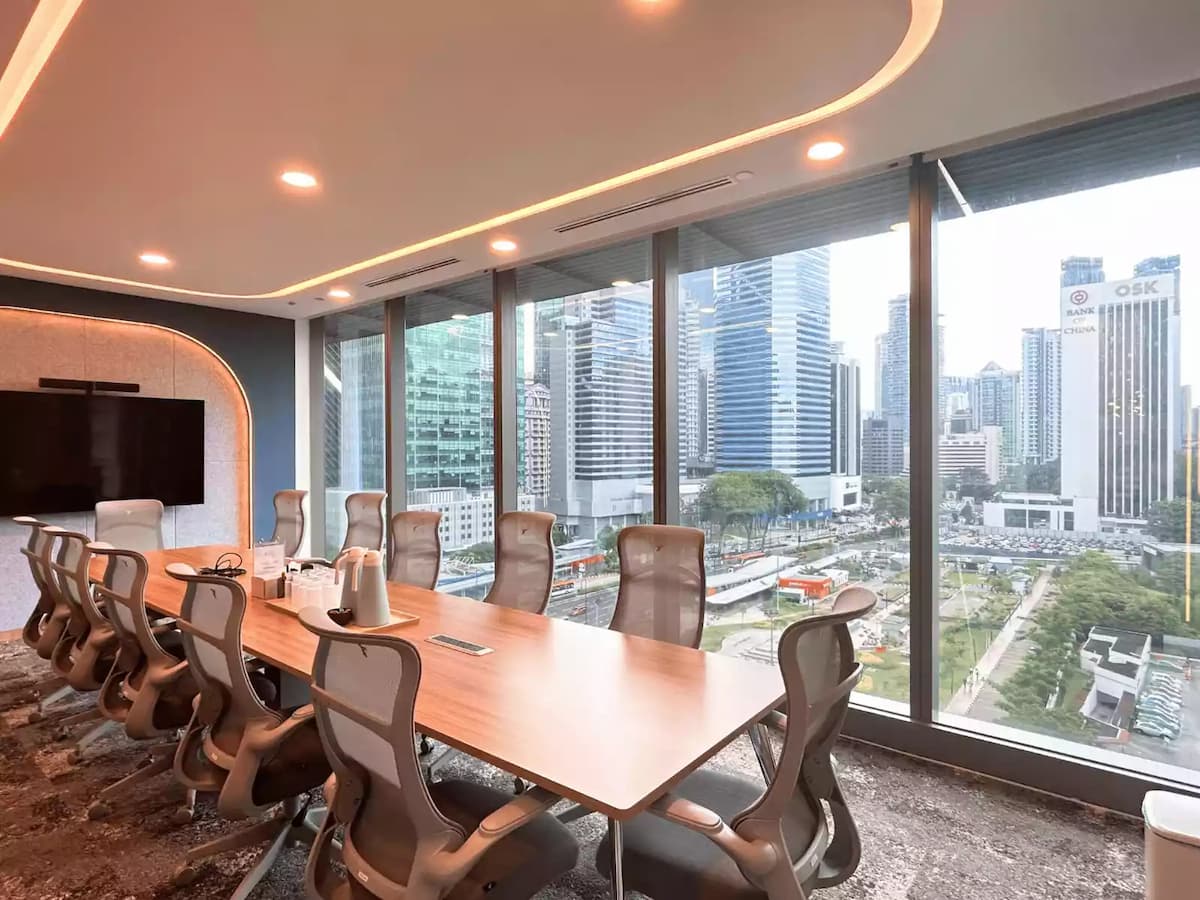 long wooden boardroom table with ergonomic chairs facing kuala lumpur city skyline at central kl corporate meeting space in malaysia