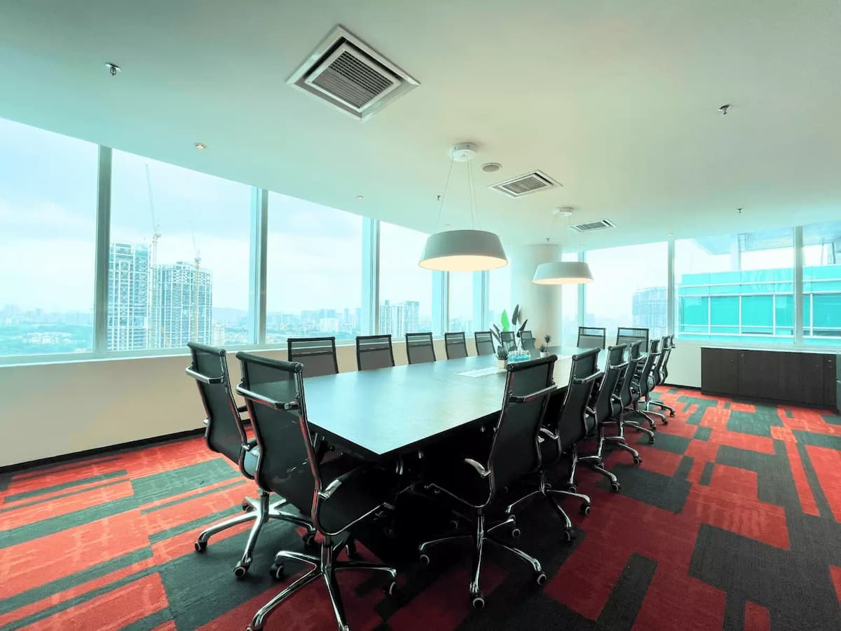 long conference table with sixteen chairs beside floor to ceiling windows overlooking the city skyline at a large boardroom event space in kuala lumpur