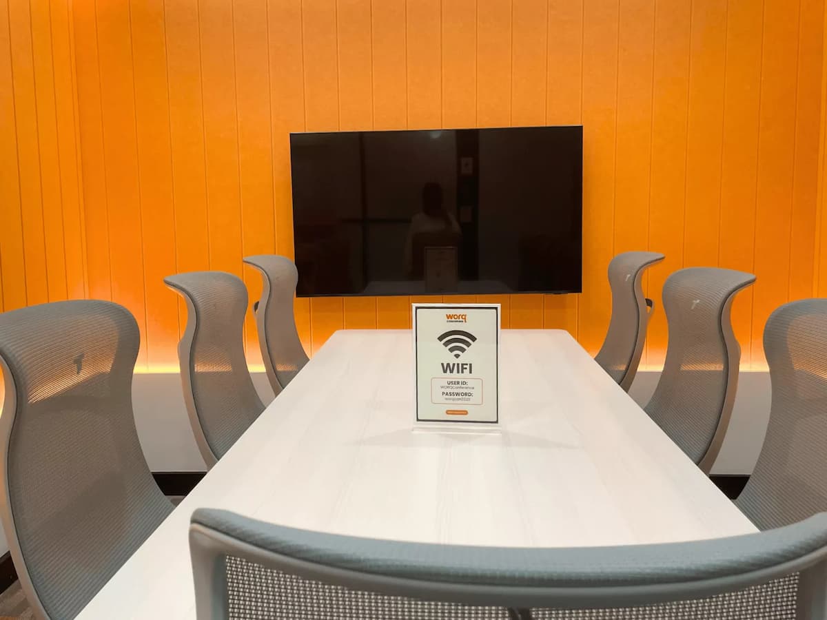 wifi sign on meeting table facing a wall mounted tv screen at affordable meeting room for rent in cheras kuala lumpur